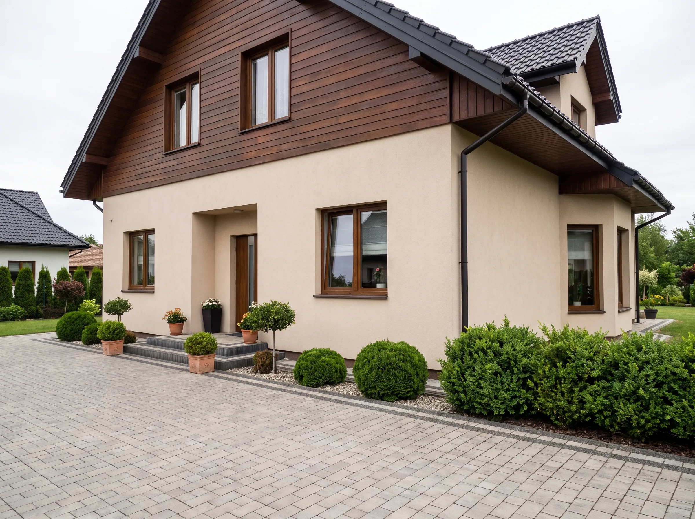 Elegancka elewacja domu z zadbaną kostką brukową i zazielenionym otoczeniem