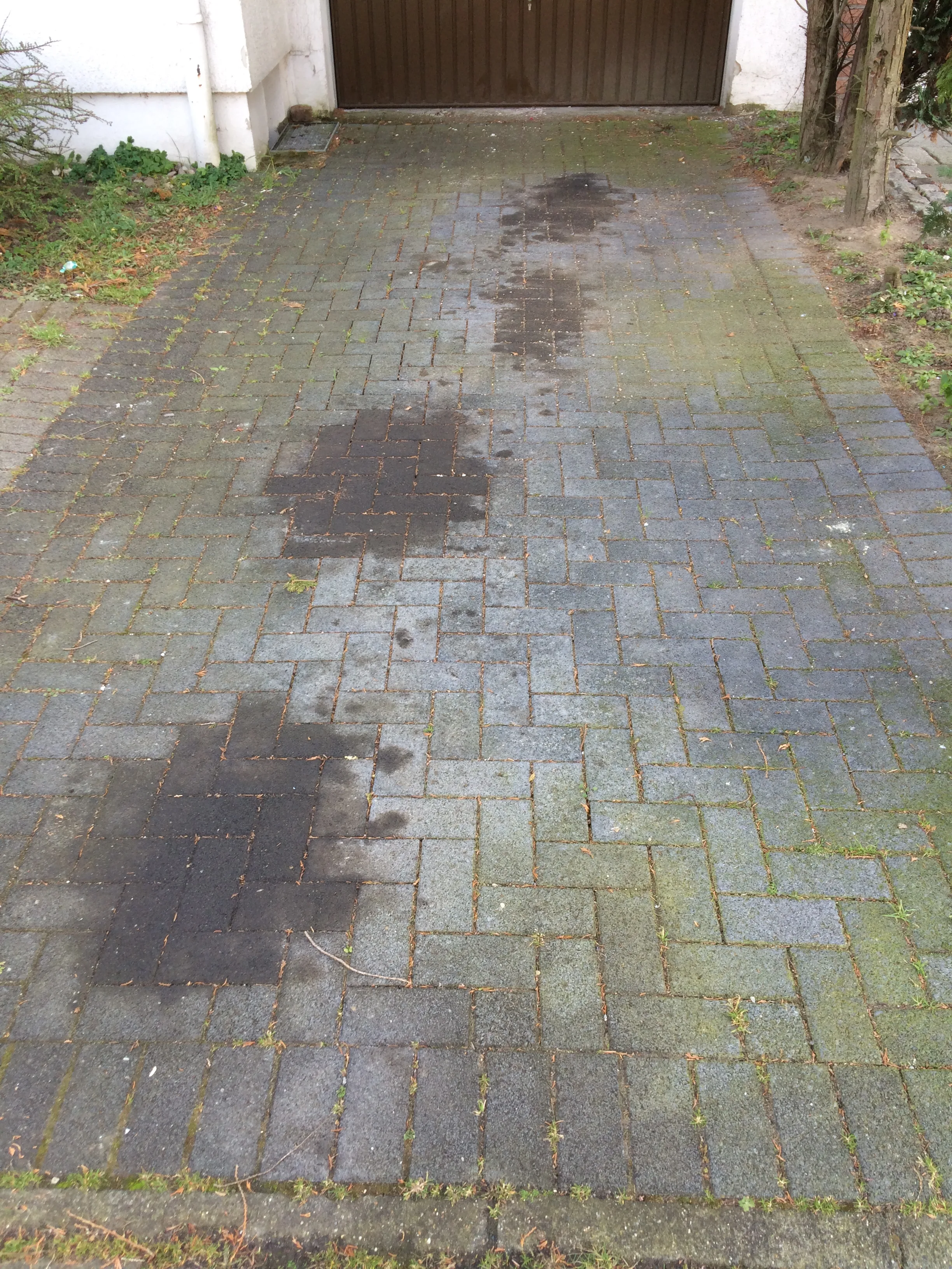 Zabrudzenia na kostce brukowej przed myciem ciśnieniowym, widoczne ślady plam